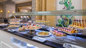 A buffet with various desserts and snacks, including cakes, pastries, and ice cream cones. - Medina Belisaire &Thalasso (Hammamet)