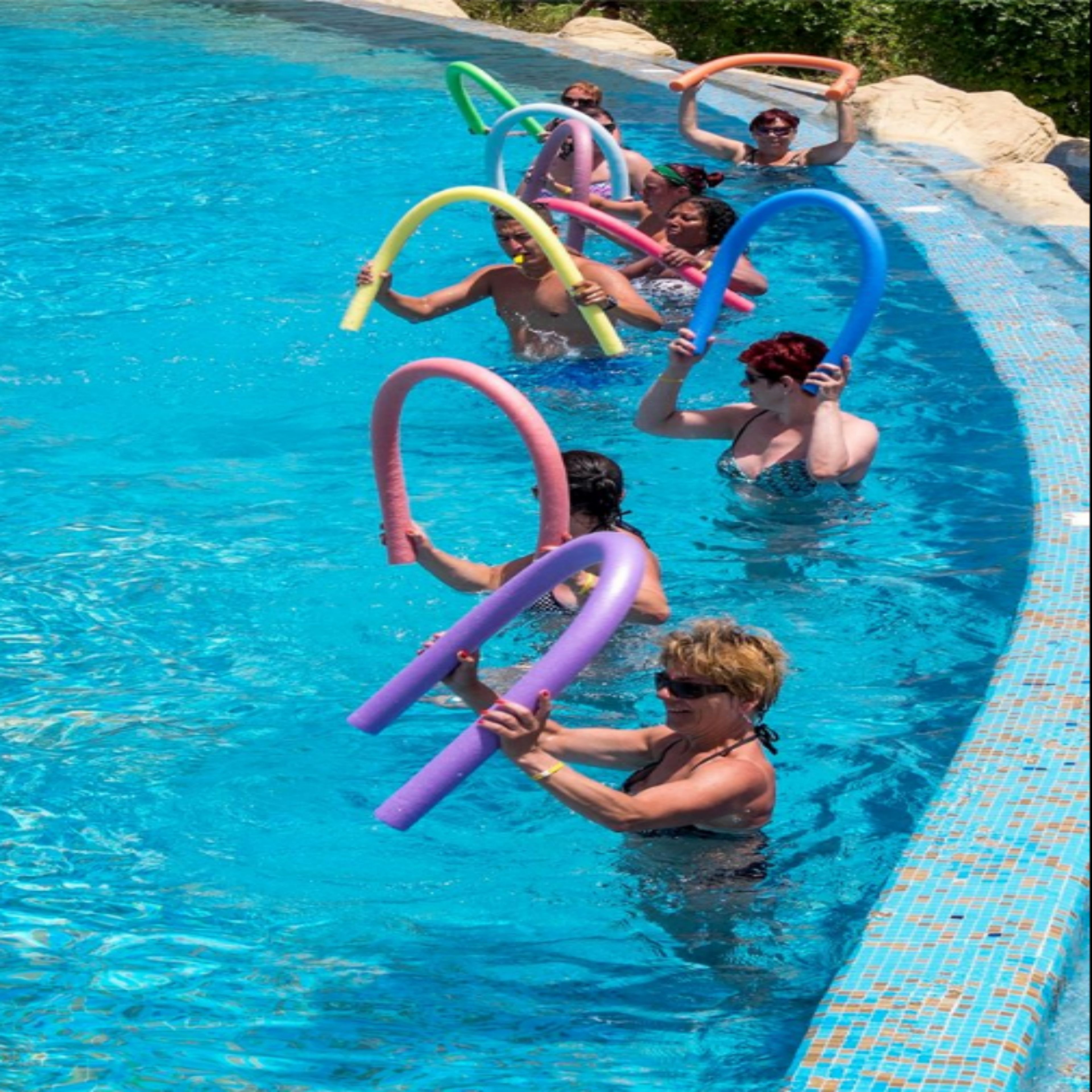 Una piscina con gente sosteniendo flotadores de colores.