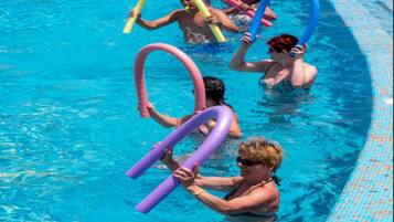 Una piscina con gente sosteniendo flotadores de colores.