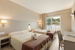 A hotel room with two beds, a desk, and a window with a view of trees. - Hotel Best Cap Salou (Salou)