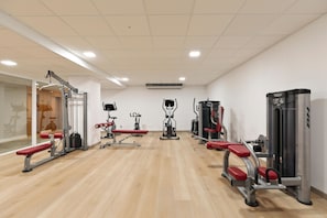 A gym with exercise equipment, wooden flooring, and white walls. - Hotel Best Cap Salou (Salou)