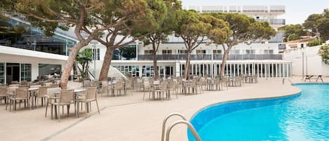 A poolside area with outdoor seating and a pool.