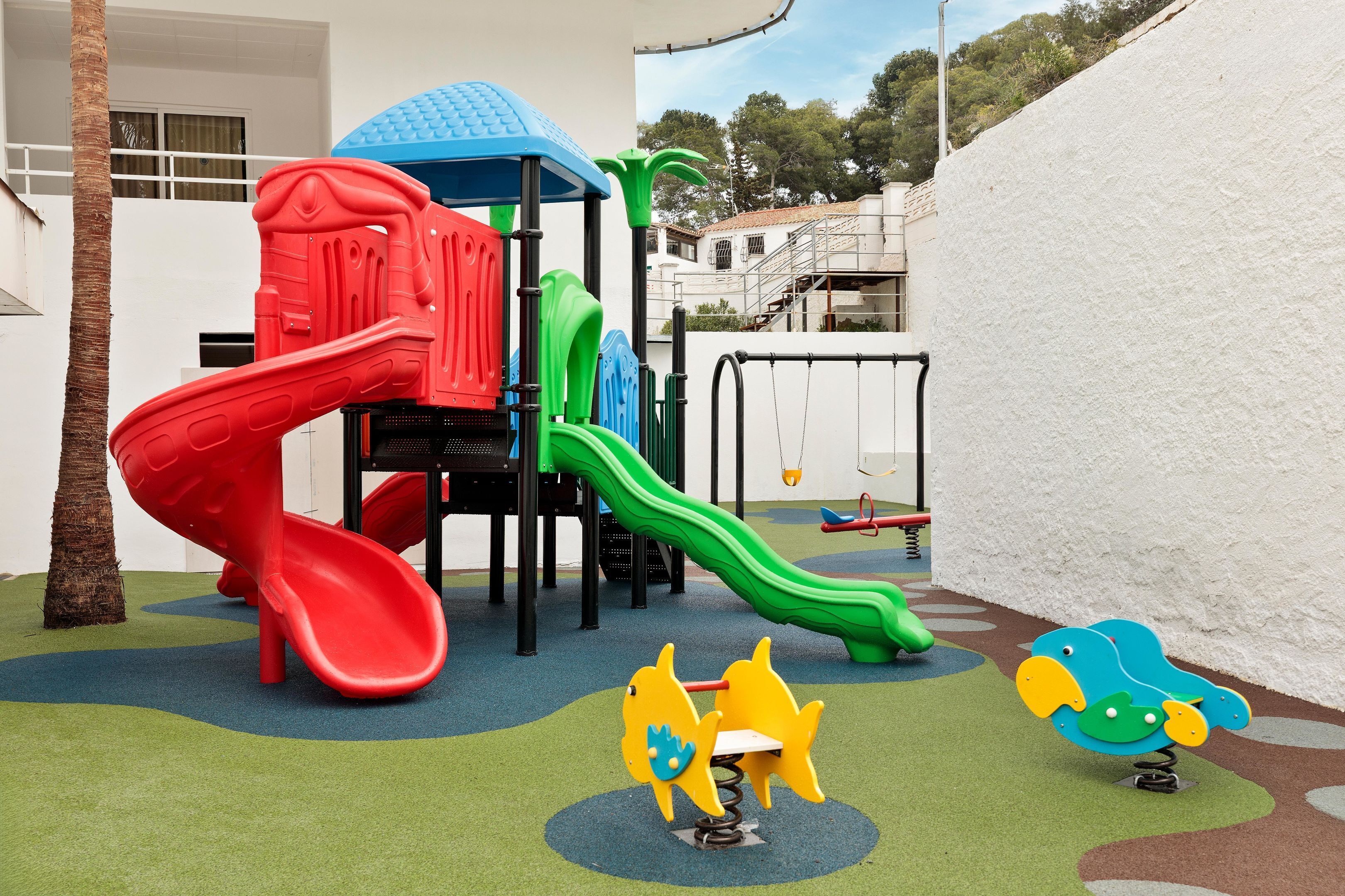 Zona de juegos infantiles con toboganes y columpios.