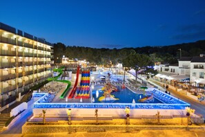 A water park with slides and pools, surrounded by buildings.