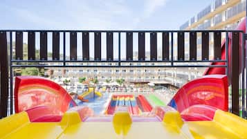 Een waterpark met verschillende glijbanen en een hotel in de achtergrond.