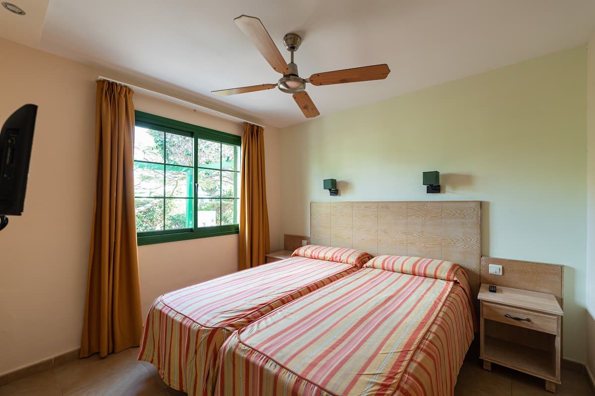 1 habitación, escritorio y tabla de planchar con plancha