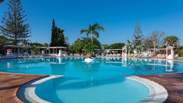 A large outdoor swimming pool with lounge chairs and palm trees. - Bungalows Cordial Sandy Golf (San Bartolomé de Tirajana)