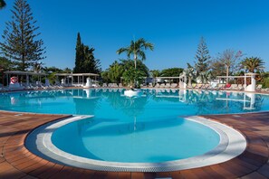 A large outdoor swimming pool with lounge chairs and palm trees. - Bungalows Cordial Sandy Golf (San Bartolomé de Tirajana)