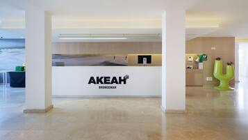 A reception area with a white counter displaying the name "AKEAH BRONCEMAR".