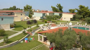 A resort with multiple buildings, a swimming pool, and outdoor seating areas. - Alkion Hotel (Kassandra)
