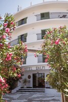 Um hotel com vários andares, varandas, uma entrada central e uma placa com a inscrição