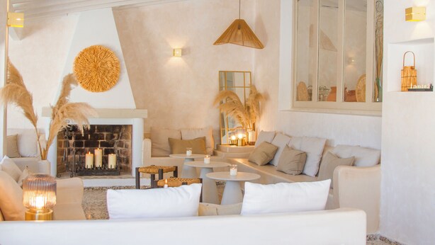 A modern living room with a fireplace, white sofas, and a large window. - Hotel Galfi - Boutique & Adults Only (Sant Antoni de Portmany)