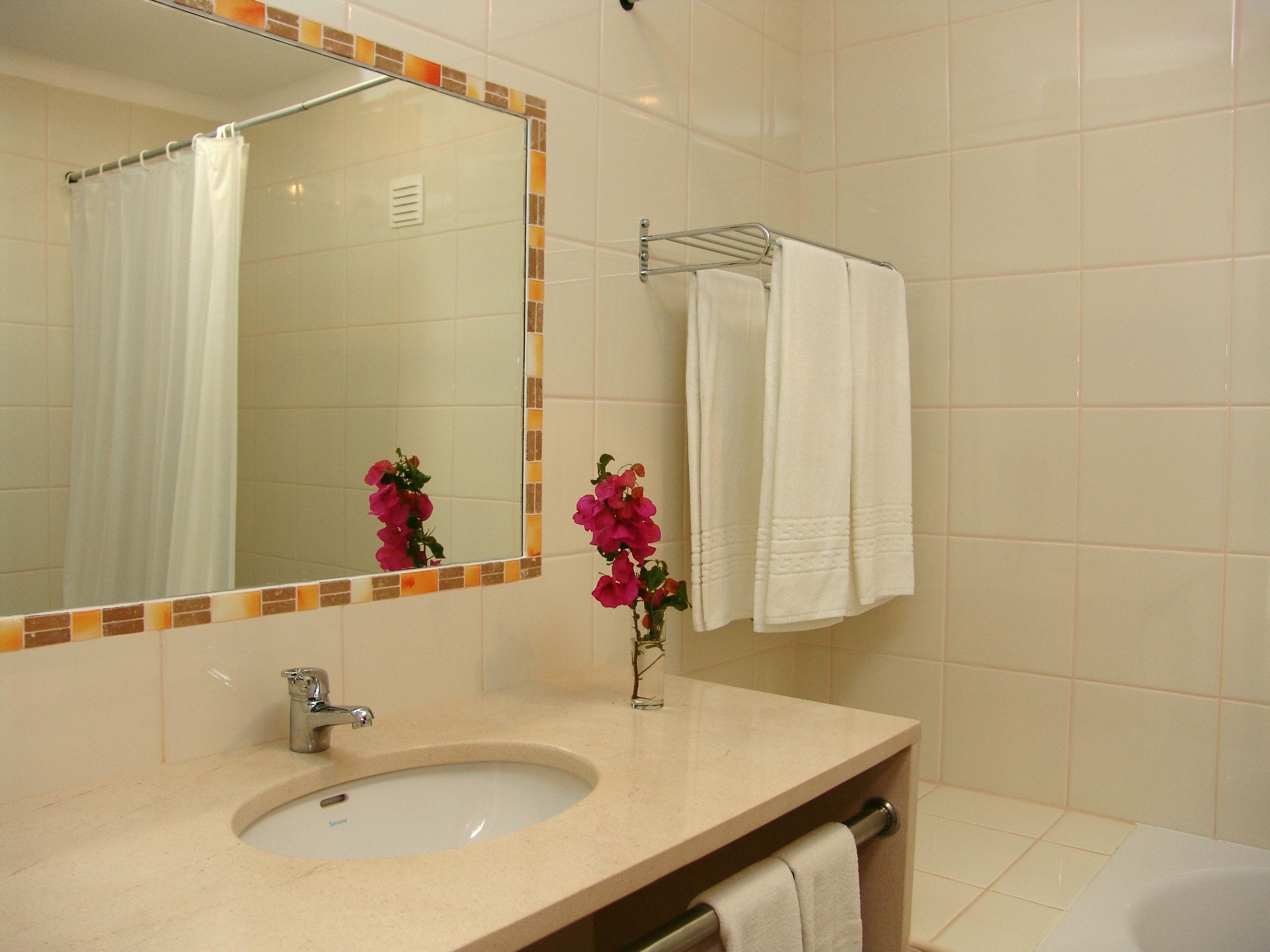 Ein Badezimmer mit Waschbecken, Spiegel und Handtuchhalter.