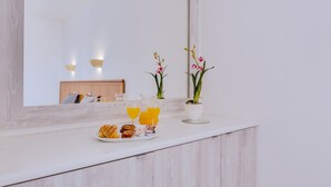 A breakfast setup with croissants, orange juice, and a small plate of pastries on a white countertop. - Hotel Vila Recife (Albufeira)