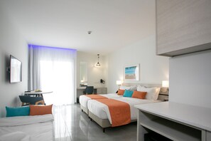 A hotel room with two beds, a desk, a chair, a small table, and a window with curtains.