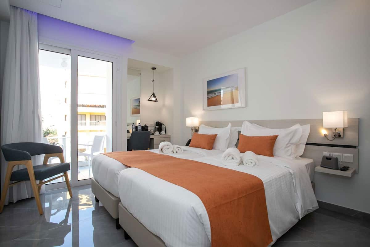 Ein Hotelzimmer mit Bett, Schreibtisch, Stuhl und Blick nach draußen.