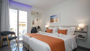 A hotel room with a large bed, a desk with a chair, a view of the outside, and a bathroom visible through an open door. - Best Western Plus Larco Hotel (Larnaca)
