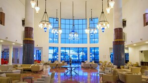 A spacious lobby with multiple seating areas, large windows, and decorative columns. - Iberostar Waves Founty Beach -All Inclusive (Agadir)