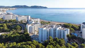 Un hôtel en bord de mer, composé de plusieurs immeubles de grande hauteur, avec une plage et une vue sur la mer.