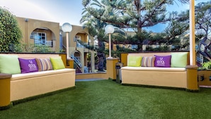 An outdoor seating area with two sofas, each with multiple cushions, and a trash bin. - Apartamentos Tisalaya Park (San Bartolome de Tirajana)