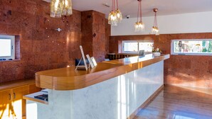 A modern reception area with a wooden reception desk, marble walls, and pendant lighting. - Apartamentos Tisalaya Park (San Bartolome de Tirajana)
