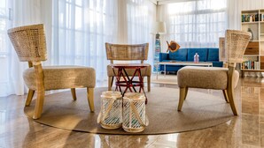 A modern living room with a round coffee table, two wicker chairs, a blue sofa, and a bookshelf. - Apartamentos Tisalaya Park (San Bartolome de Tirajana)