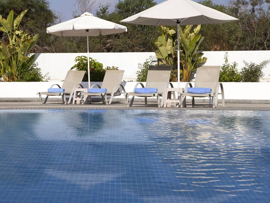 Ett poolområde med solstolar och parasoller.