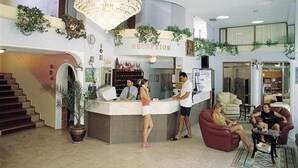 A reception area with a counter, a chandelier, and a staircase. - Minay (Kusadasi)
