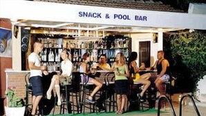 A poolside bar with a sign reading "SNACK & POOL BAR" and several people seated at tables. - Minay (Kusadasi)