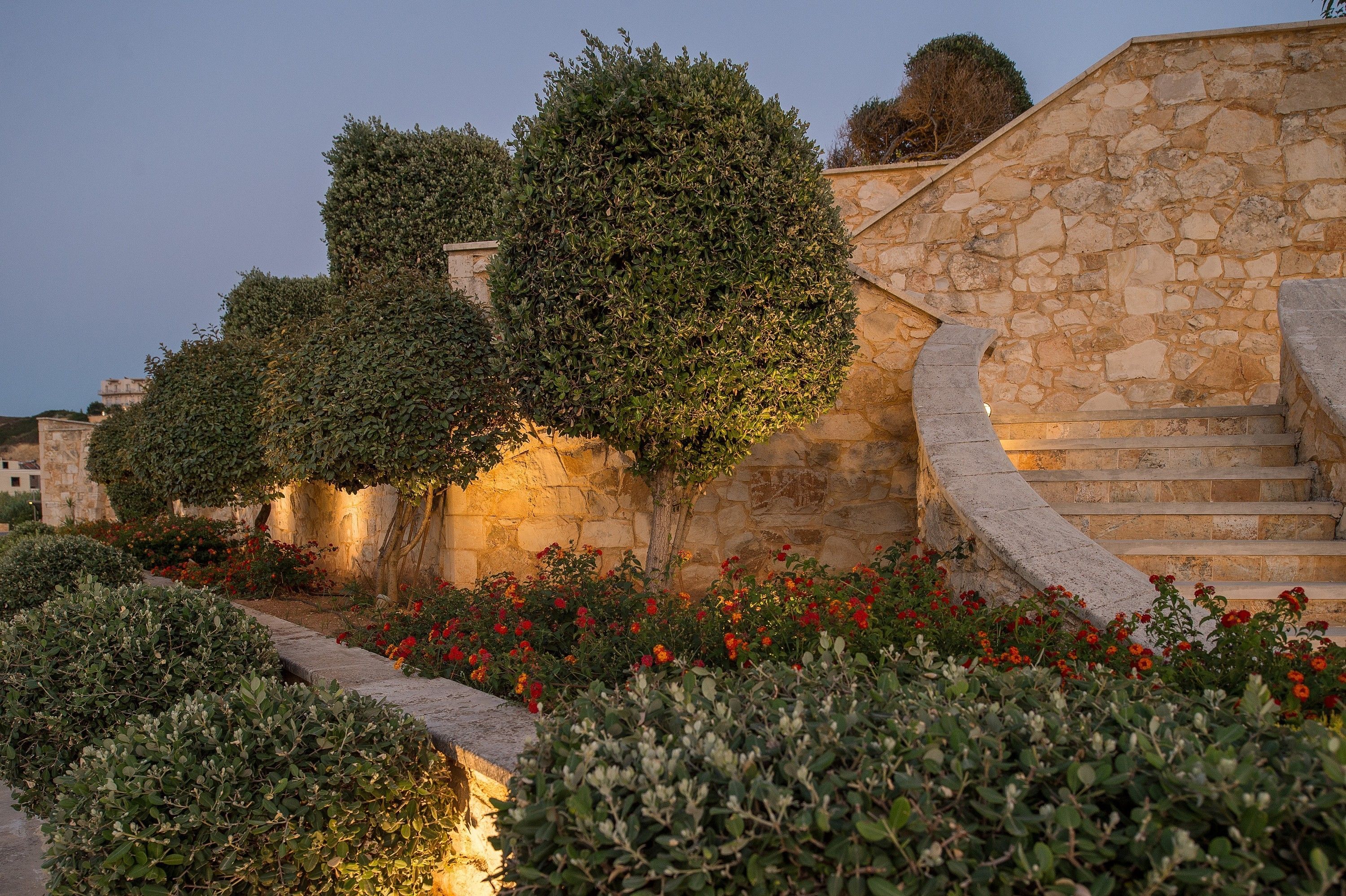 A stone staircase leading up to a building with a garden in front.