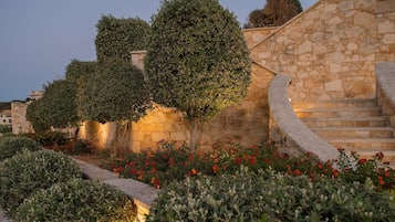 A stone staircase leading up to a building with a garden in front.