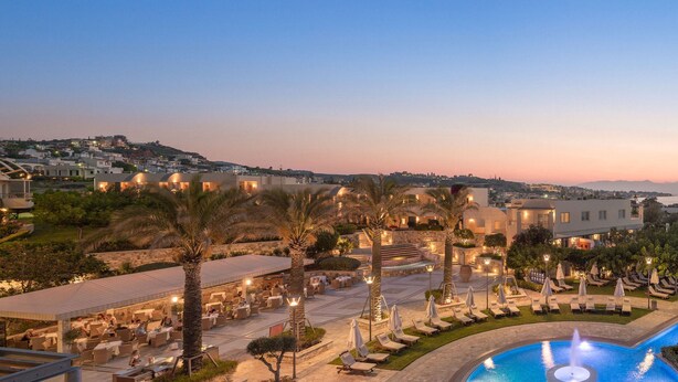 Un resort con piscina, mobiliario exterior y vistas al mar.