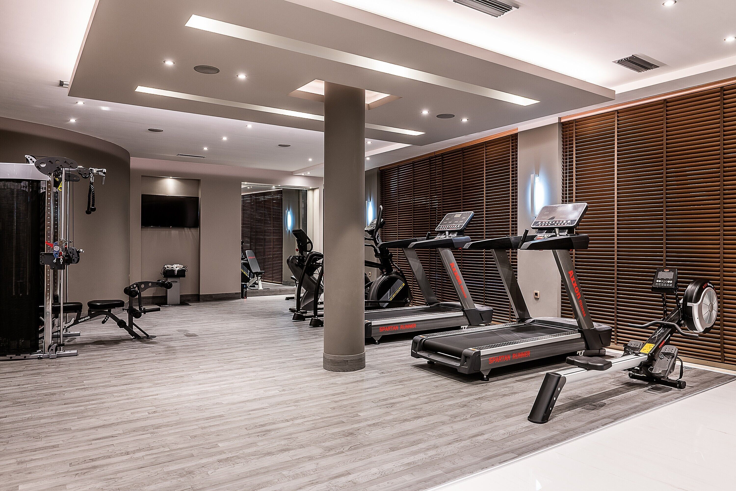 Un gimnasio moderno con cintas de correr, bicicletas estáticas y máquinas de pesas.