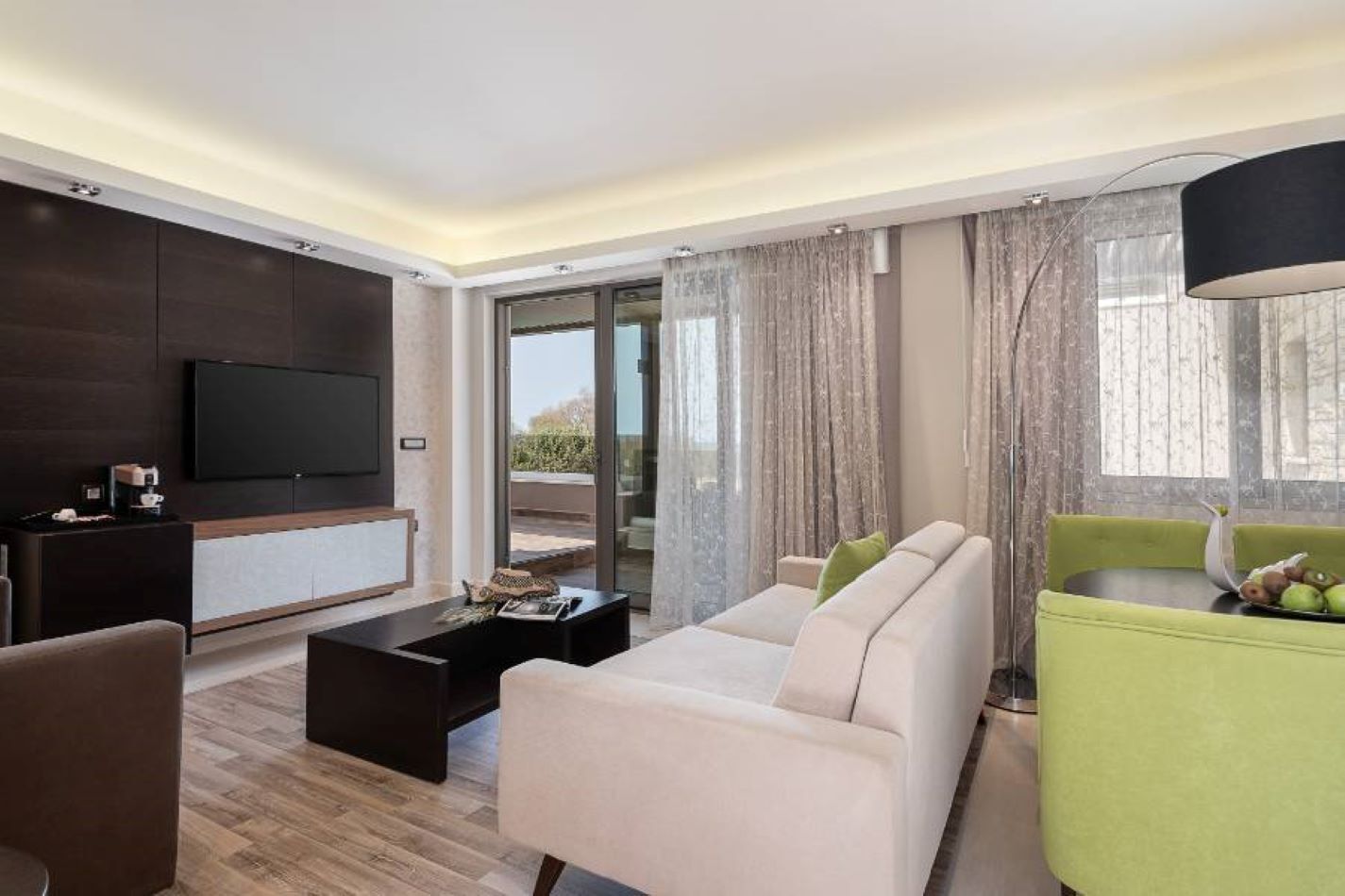 Una sala moderna con un sofá, una mesa de centro y un televisor montado en la pared.
