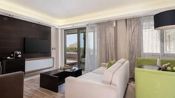 Una sala moderna con un sofá, una mesa de centro y un televisor montado en la pared.