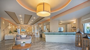 A spacious living area with a central island, a dining area, and a kitchen. - Nefeli Hotel (Rethymno)