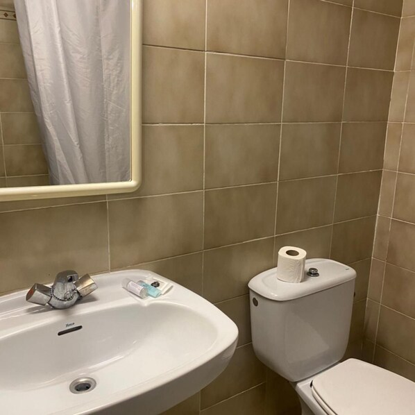 A bathroom with a sink, toilet, and a mirror. - Hotel Clipper (Lloret de Mar)