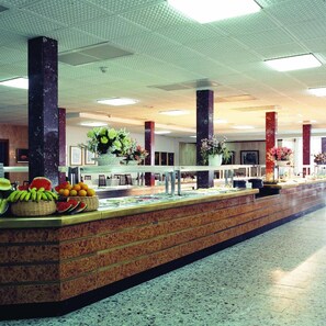 A buffet area with a marble counter, various fruits, and flowers. - Hotel Clipper (Lloret de Mar)