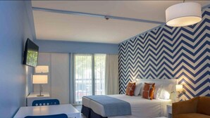 A modern hotel room with a bed, a desk, a chair, and a television.
