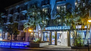 A hotel named 'Terrace Mar' with a modern facade, balconies, and a well-lit entrance.
