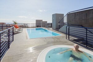室外游泳池，提供泳池遮陽傘和日光浴躺椅