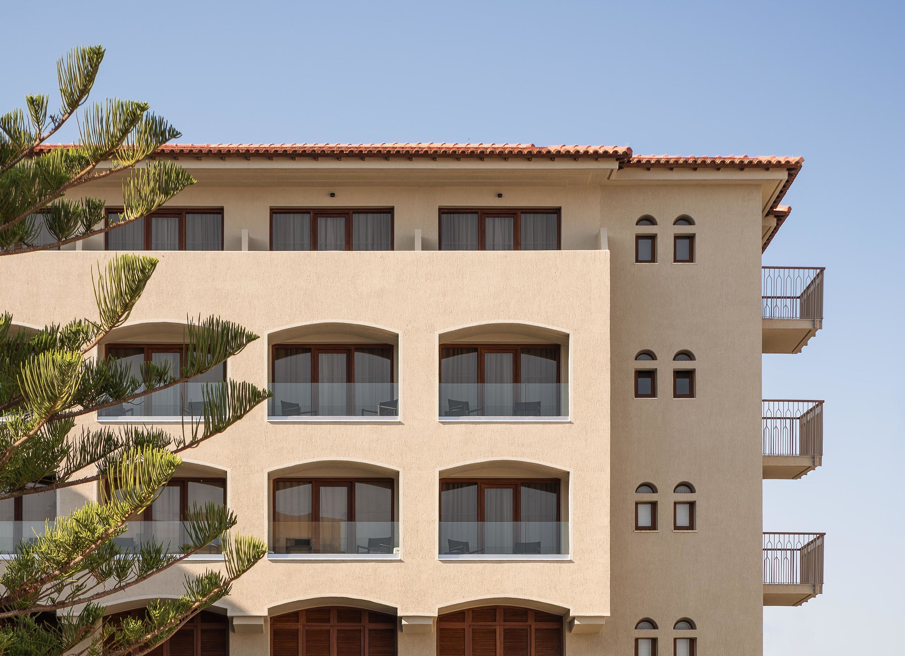 A multi-story building with balconies and large windows.