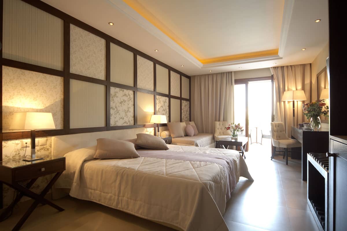 Une chambre d’hôtel avec un grand lit, des tables de chevet, un bureau et une chaise.