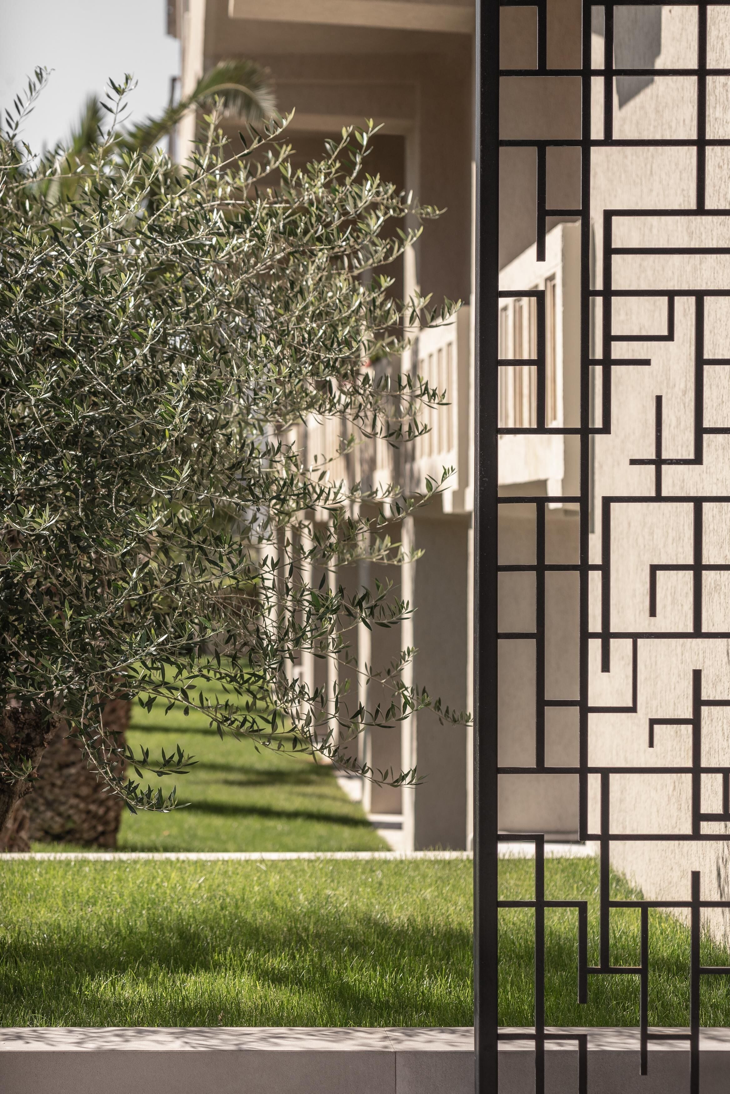 Un bâtiment à la façade géométrique et doté d’une pelouse bien entretenue.