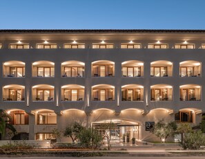 A multi-story hotel with arched windows and a central entrance. - Theartemis Palace (Rethymno)