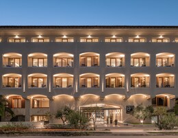 A multi-story hotel with arched windows and a central entrance.