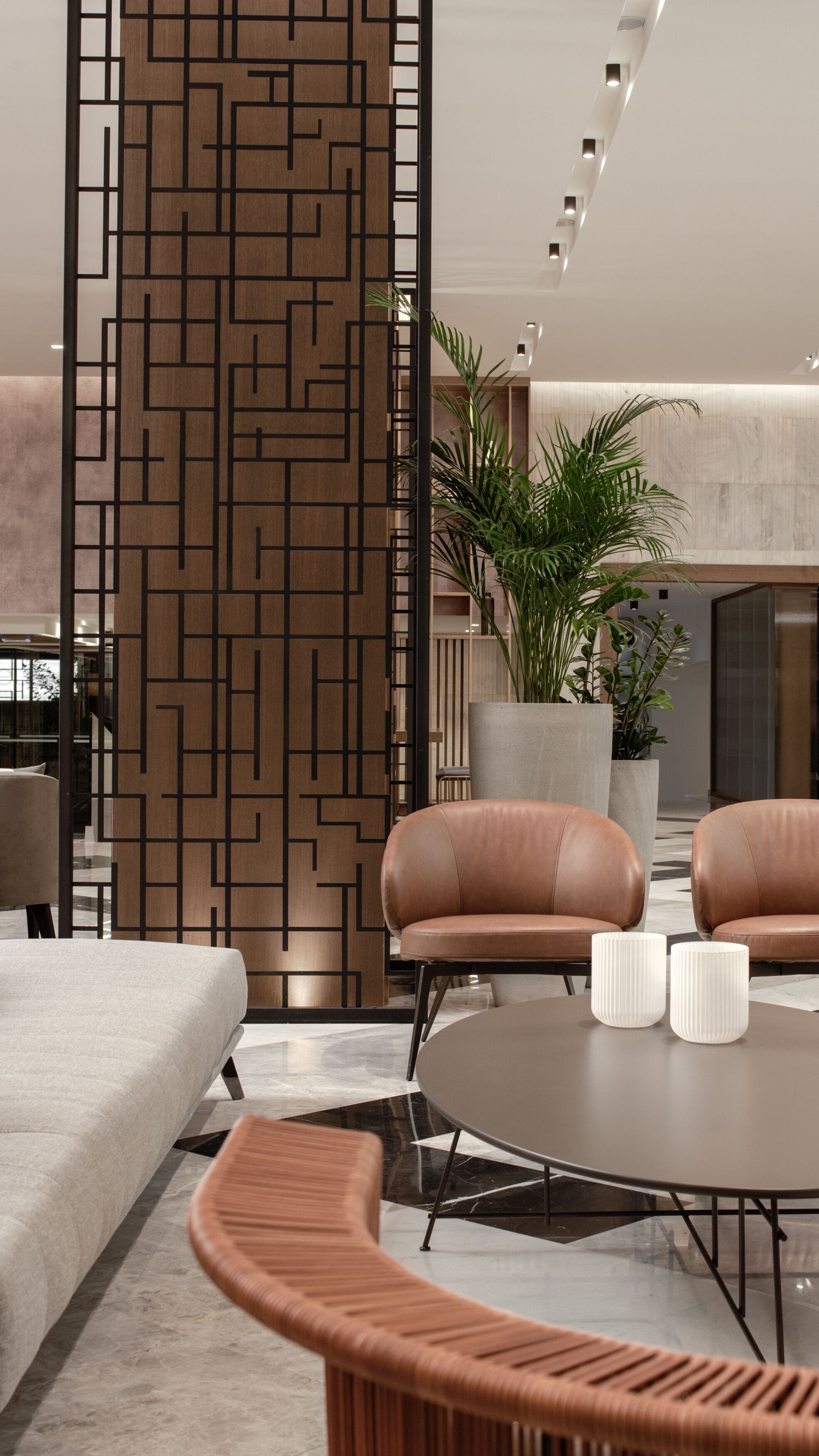A modern interior with a sectional sofa, a round coffee table, and a decorative wooden partition.