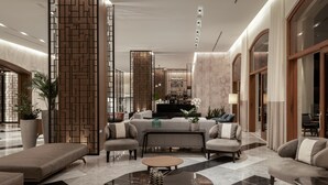 A modern lobby with a central seating area, a bar, and a reception desk.