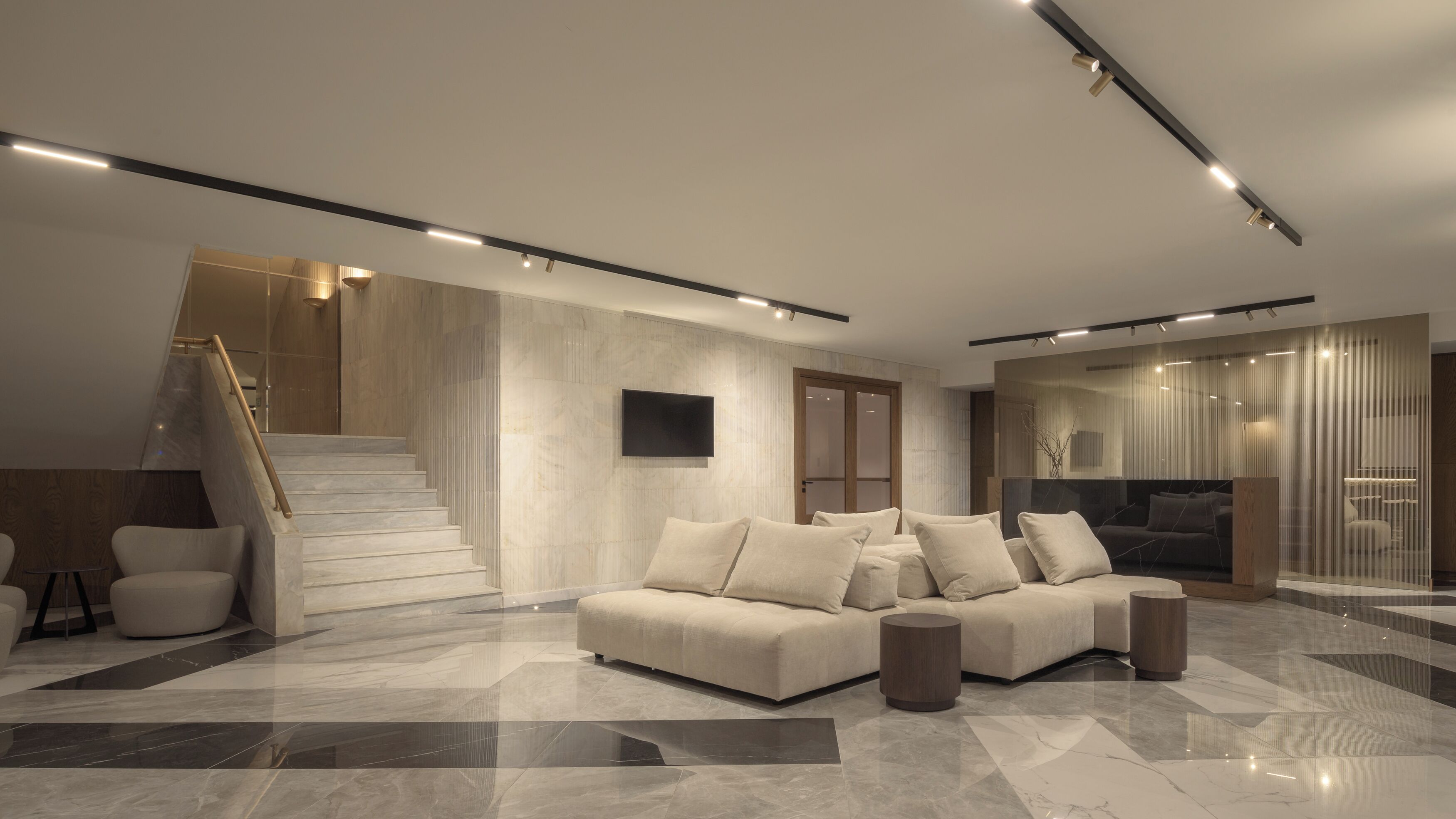 Ein modernes Wohnzimmer mit Sofa, Couchtisch und Treppe.