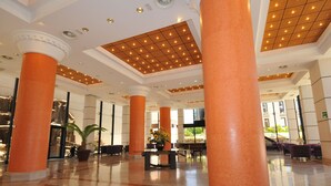 A spacious lobby with high ceilings, large columns, and a polished floor. - Hotel Zentral Center (Arona)